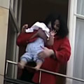 Michael Jackson dangles his baby over a hotel balcony.